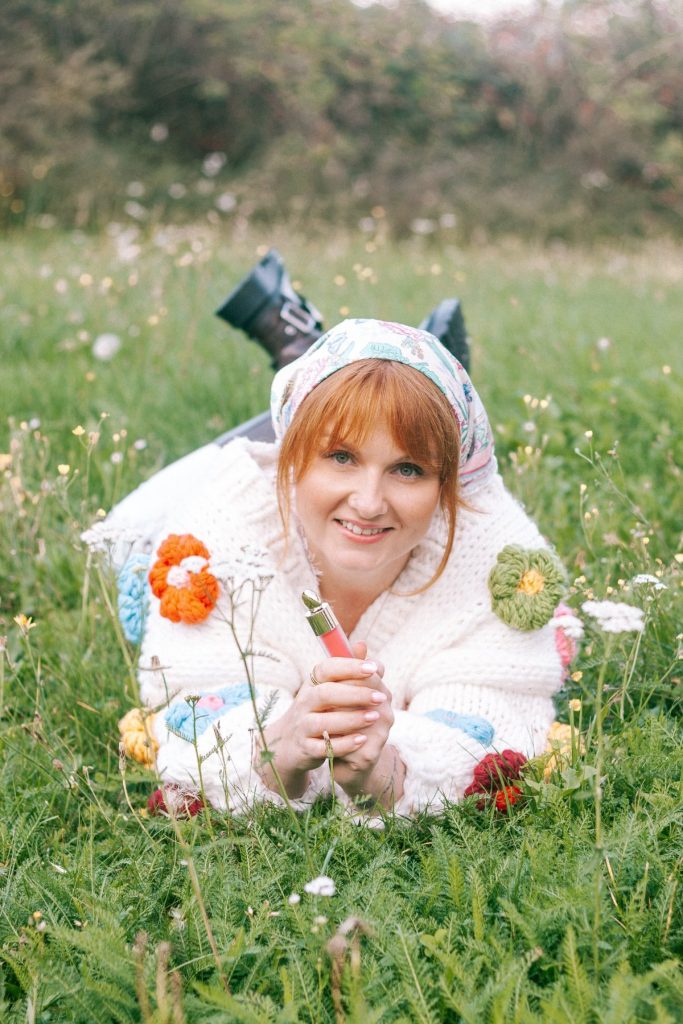 Sandra Duda leży na łące z błyszczykiem